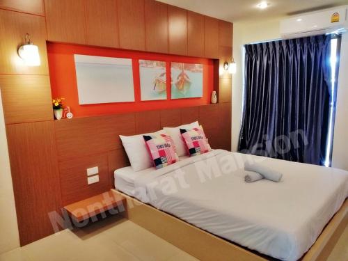 a bedroom with a large bed and a window at Nontharat Mansion in Nonthaburi