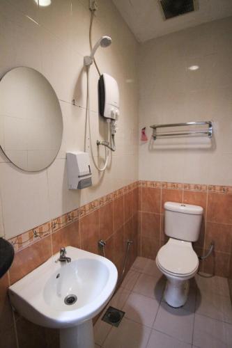 a bathroom with a sink and a toilet and a mirror at Rose Cottage Hotel Taman Perling in Johor Bahru