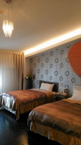 a hotel room with two beds and a chandelier at Formosa Vacation Village Homestay in Renai
