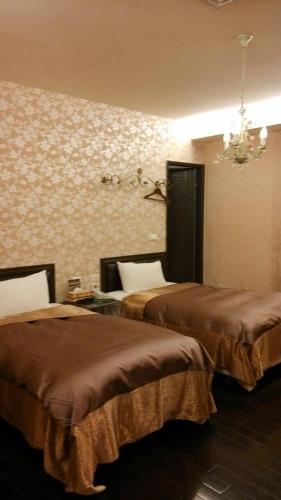 a hotel room with two beds and a chandelier at Formosa Vacation Village Homestay in Renai