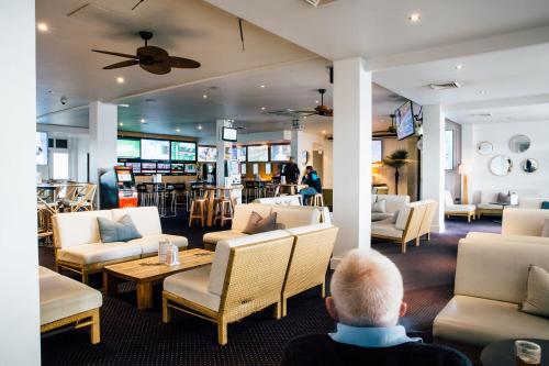 a living room filled with furniture and people at Crossroads Hotel in Liverpool