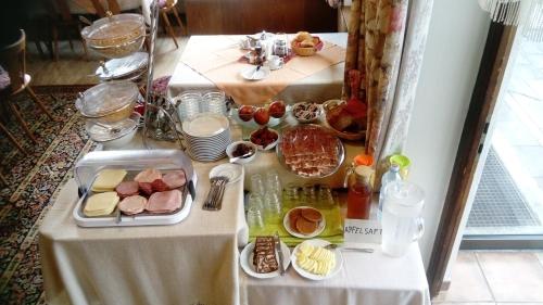 a table with food and plates of food on it at Gästehaus Loithaler in Fügen