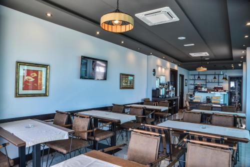 a dining room with tables and chairs and a bar at Padam Hotel & SPA in Ulcinj