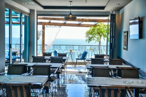 a restaurant with tables and chairs with a view of the ocean at Padam Hotel & SPA in Ulcinj
