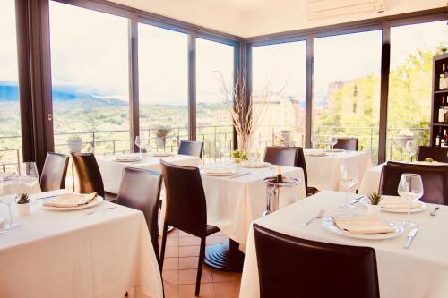 a restaurant with white tables and chairs and large windows at Hotel Ristorante Garibaldi in Frosinone