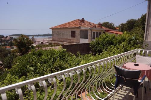 a balcony with a table and chairs and a house at Tanya-Apartments and Rooms in Hvar