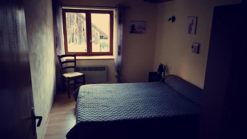 niewielka sypialnia z łóżkiem i oknem w obiekcie Le balcon fleuri w mieście Freissinieres