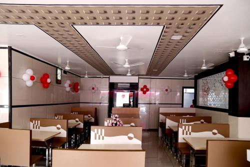 een restaurant met tafels en stoelen en rode ballonnen bij Hotel Shahi Darbar in Navsāri