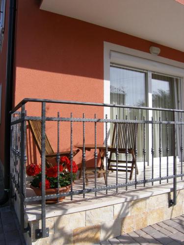a balcony with two chairs and flowers on a building at Apartments Nina in Umag
