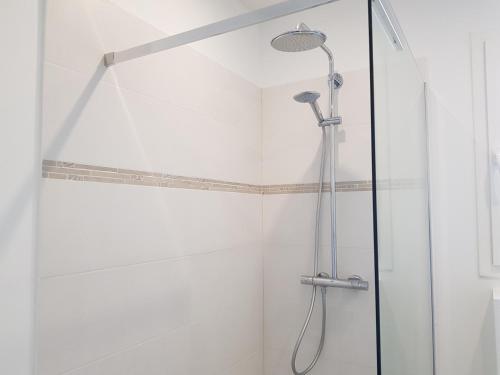 une douche avec une porte vitrée dans une salle de bain dans l'établissement Azurea, à Valbonne