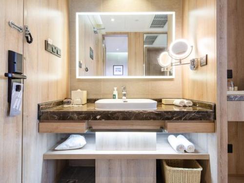 a bathroom with a sink and a mirror at Atour Hotel Suzhou Industrial Park Qingjian Lake Branch in Suzhou