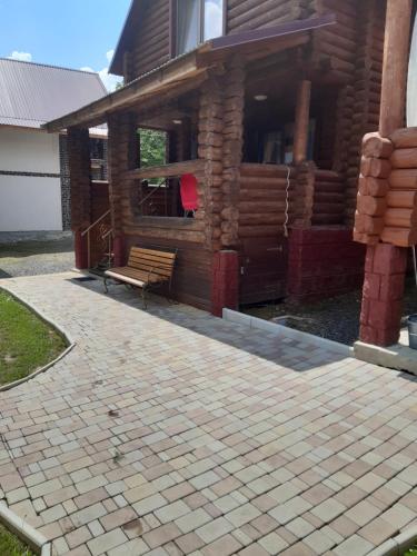 a bench sitting in front of a building at "Карпатський краєвид" in Polyana