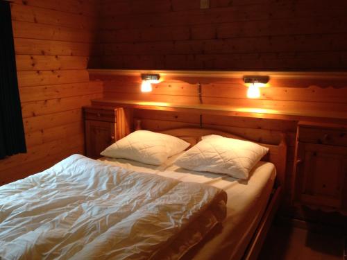 um quarto com uma cama com duas almofadas e luzes em Chalet Dennerust - The Original em Durbuy