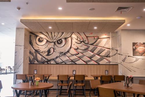 a mural in a restaurant with tables and chairs at All Nite & Day Kebon Jeruk in Jakarta