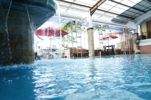 una piscina con una fuente de agua en HOTEL ASRI CIREBON, en Cirebon