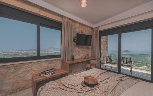 a bedroom with a large bed and large windows at Zinos Luxury Villa in Lithakia