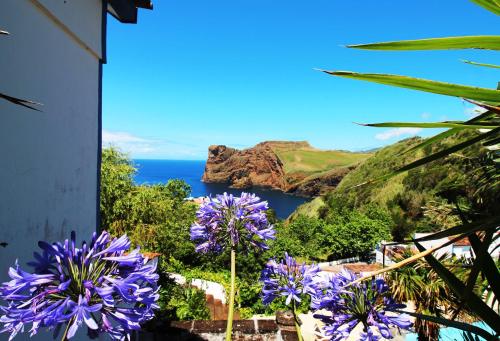 a view of the ocean from a house with purple flowers at Quinta Do Canavial in Velas