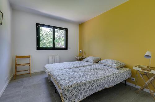 een slaapkamer met een bed en een raam bij Maison du Prignon in Saint-Marc-Jaumegarde