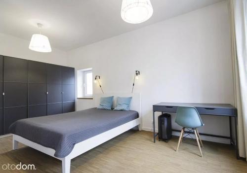 1 dormitorio con cama, escritorio y silla en Stylowy 2-pokojowy apartament 5 min. od Rynku, en Wroclaw