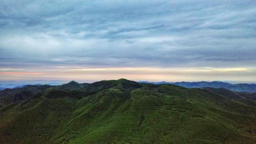 a view of a green mountain with a cloudy sky at Moganshan Pinhouwu Hotel in Deqing