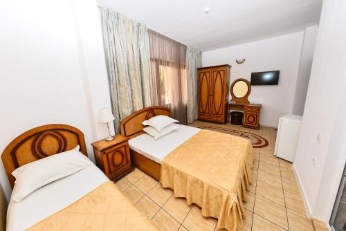 a hotel room with two beds and a mirror at Vila Eden in Eforie Nord
