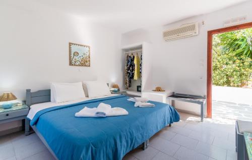 a bedroom with a blue bed with towels on it at Pension Ioanna in Adamantas