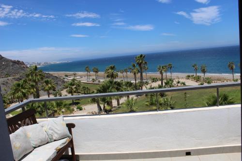 einen Balkon mit Blick auf den Strand und einer Bank in der Unterkunft Primera Linea Mojacar in Mojácar