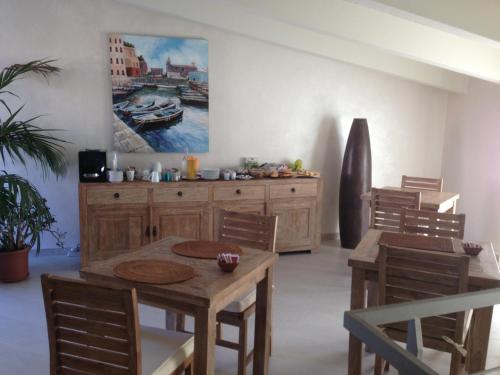 a dining room with a table and chairs and a painting at La casa di Pier in Olbia