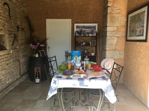 ein Tisch mit Essen und Getränken darauf in der Unterkunft La Chambre des Buissonnats in Martailly-lès-Brancion