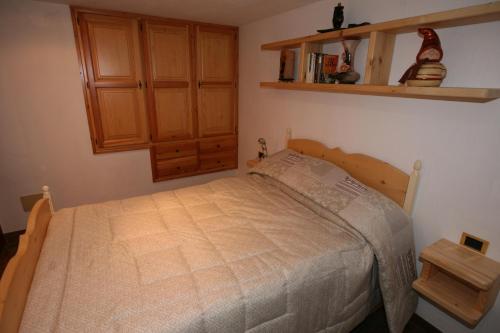 a bedroom with a bed and a wooden cabinet at SUITE DEL VILLAGGIO in Aosta