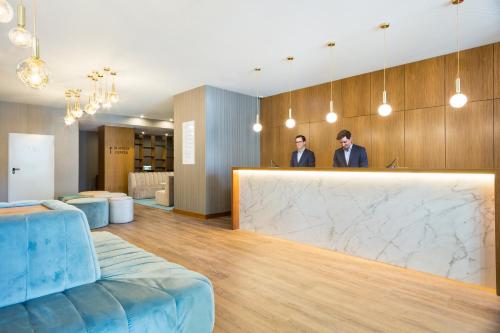 two men standing behind a counter in a lobby at Acta The Avenue in Porto