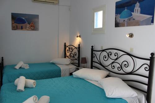 two beds in a room with blue and white at Spiridoula Villa - Santorini Seaside Retreats in Perissa