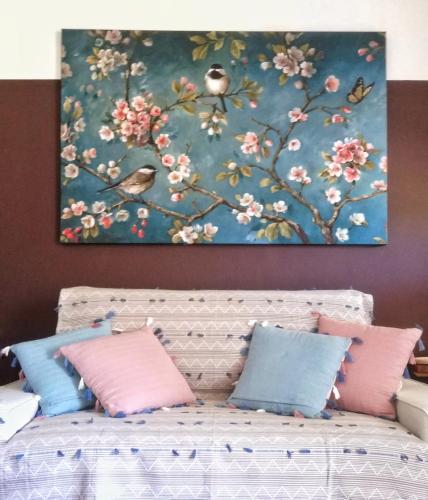 a painting above a bed with pink and blue pillows at Podere L'Olmaia in Marsiliana