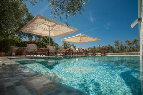 a swimming pool with chairs and umbrellas at Villa Stevan in Sveti Stefan