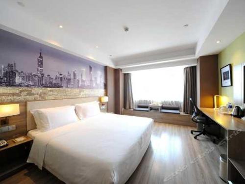 a bedroom with a large white bed and a desk at Atour Hotel (Nanjing Hunan Road) in Nanjing