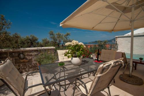 a table with a vase of flowers on a patio at Villa Stevan in Sveti Stefan