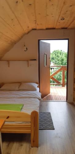 1 dormitorio con 1 cama en una casa de madera en Domek nad Krutynią, en Piecki