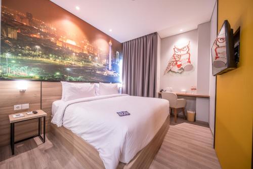 a hotel room with a white bed and a tv at All Nite & Day Kebon Jeruk in Jakarta