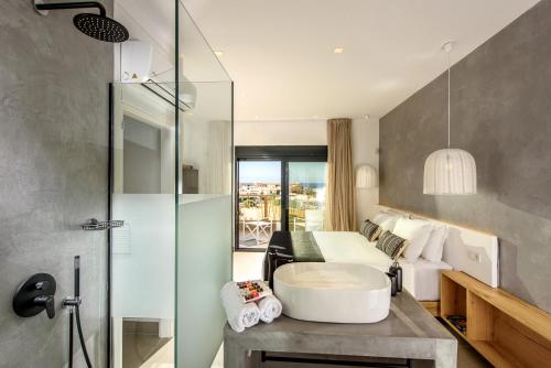 a bathroom with a bath tub and a bedroom at Calma Villas Crete - heated pool in Sissi