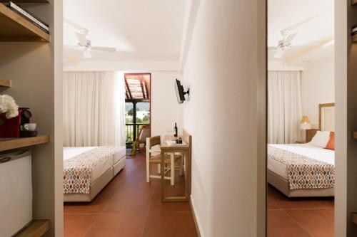 マリアにあるKalypso Hotelのベッド2台とテーブルが備わるホテルルームです。