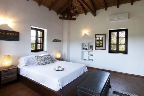 a bedroom with a bed and a table and two windows at Tresor Boutique Home in Kolios