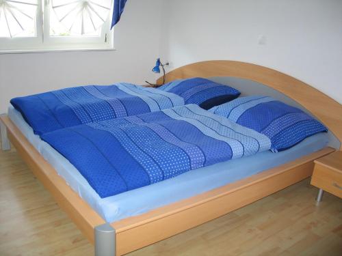 ein Bett mit einer blauen und weißen Decke drauf in der Unterkunft Haus Diesenhof in Lauterbach