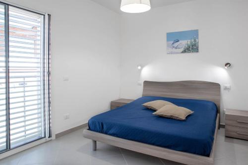 una camera con un letto blu e una grande finestra di Oasi Casa Vacanze a Loano