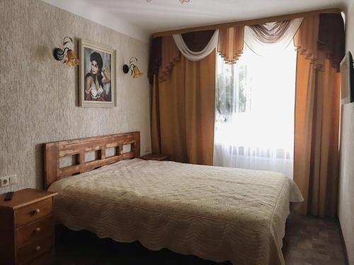 - une chambre avec un lit et une grande fenêtre dans l'établissement P. Stradiņa iela 17 Апартаменты, à Ventspils