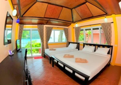 een slaapkamer met 2 bedden in een kamer met ramen bij Phi Phi View Point Resort in Phi Phi Don