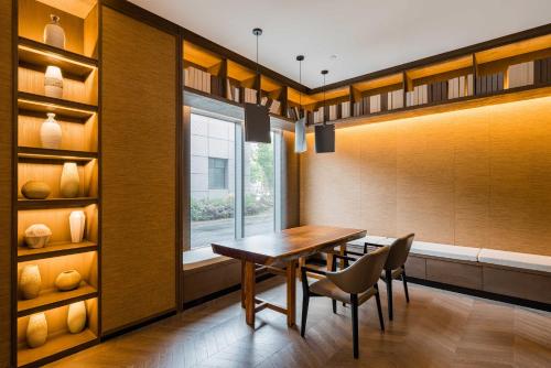 a dining room with a table and chairs and a window at Yunhe Yebo Hotel (Shanghai International Tourism Resort Pudong Airport) in Shanghai