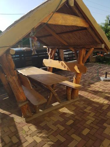 estructura de madera con mesa y silla en Pagrepe apartman, en Balatonvilágos