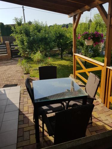 d'une terrasse avec une table, des chaises et une clôture. dans l'établissement Pagrepe apartman, à Balatonvilágos