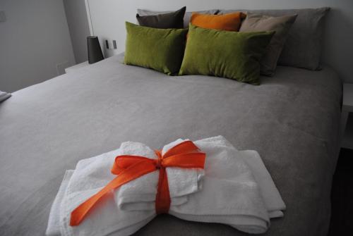 a white towel with a red ribbon on a bed at DolceLago in Sirone
