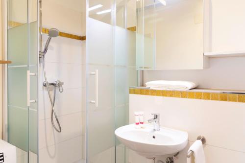 een badkamer met een douche en een wastafel bij Nest - Badenerstrasse 356 in Zürich